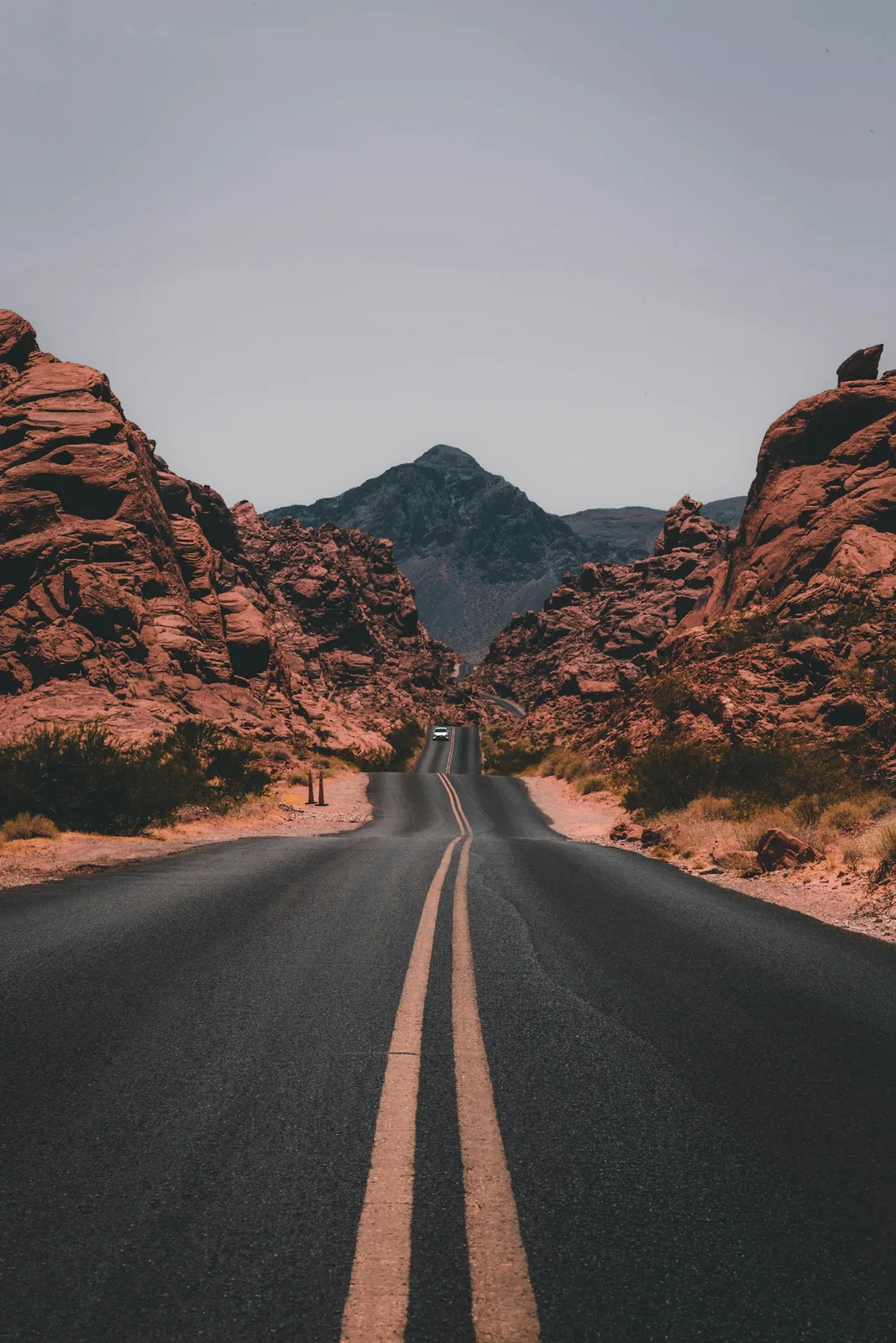 An empty desert road leading toward mountains.